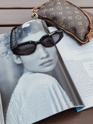 Bilde av solbrille på magasin med bilde av jente