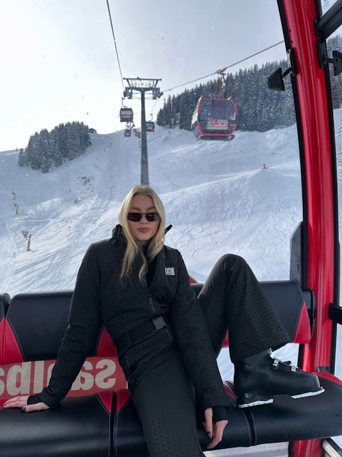 Jente med solbriller poserer i skiheis