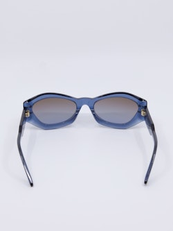 Solbrille i transparent blåfarge og lekre detaljer i front og på brillestenger