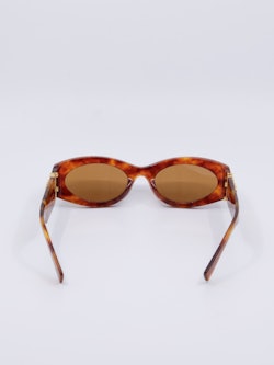 Smal solbrille i en rødbrun farge med gule solbrilleglass