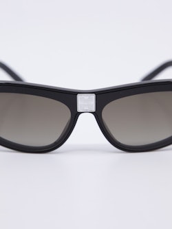 Solbrille med svak cateye i svart og duse brilleglass