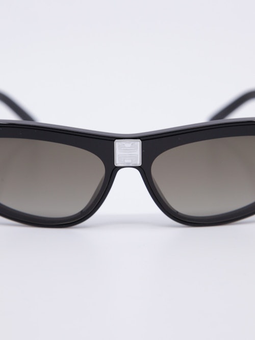 Solbrille med svak cateye i svart og duse brilleglass