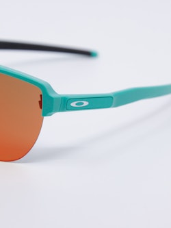 Sportsbrille med store solbrilleglass i oransje og brillestenger i turkis