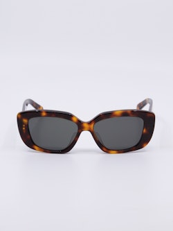 Mørkebrun solbrille med avrundet svak cateye fasong