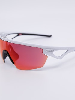 Sportsbrille med hvit ramme og rosa solbrilleglass.