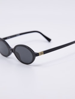 Svart og oval solbrille med nette brillestenger