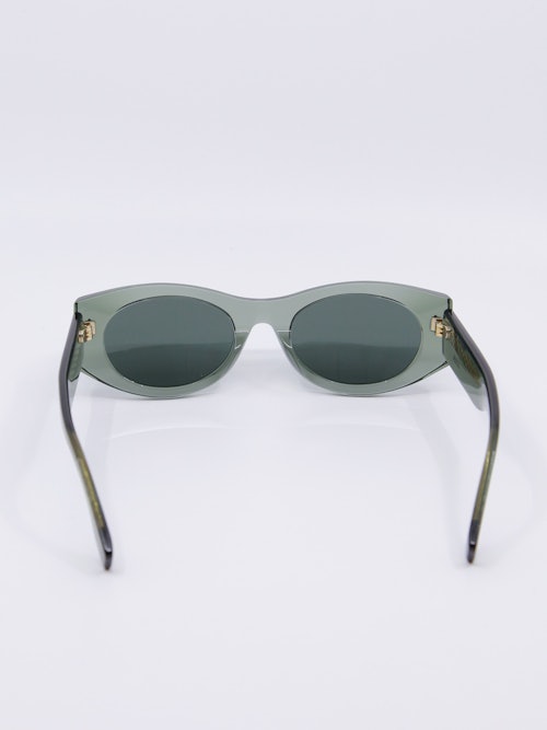 Solbrille med transaprent grønn ramme og mørkegrå solbrilleglass