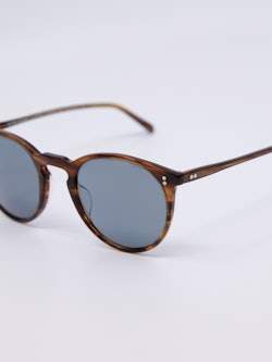 Rund solbrille med brun ramme og blå solbrilleglass nær
