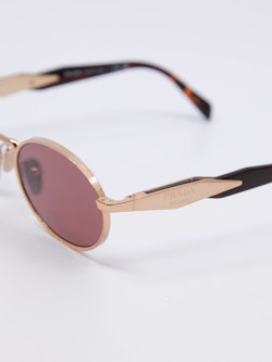 Oval metallsolbrille i gull med rosa solbrilleglass