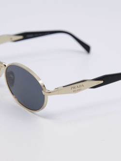 Oval metallsolbrille i gull med blå solbrilleglass