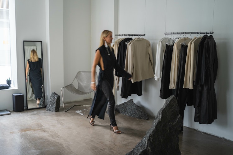 Celine Aagaard i sitt studio, på vei bort til en rekke med klær.