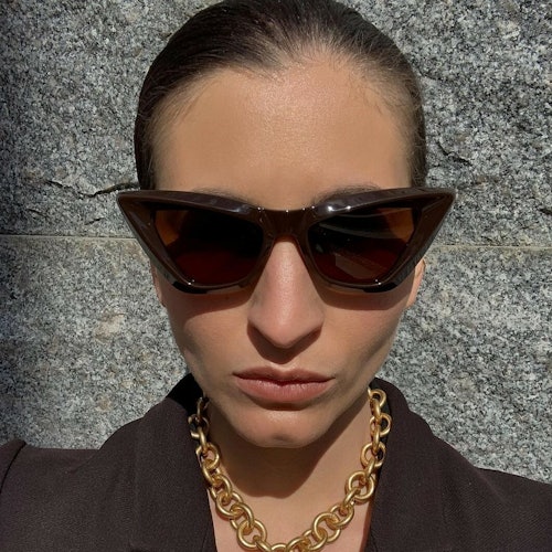 Portrett utendørs av moteblogger Katarina Petrovic iført brun cateye solbrillle fra Bottega Veneta