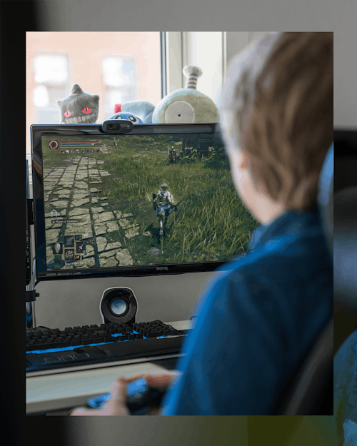 PC-skjerm i fokus, gutt som gamer