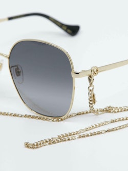 Detaljebilde av solbrille med brillesnor fra Gucci