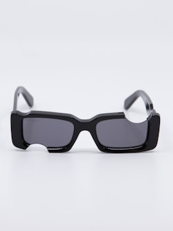 Sort solbrille med cut-out design og Off-White logo på brillestengene, bilde forfra