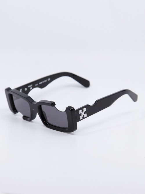 Sort solbrille med cut-out design og Off-White logo på brillestengene, bilde fra siden