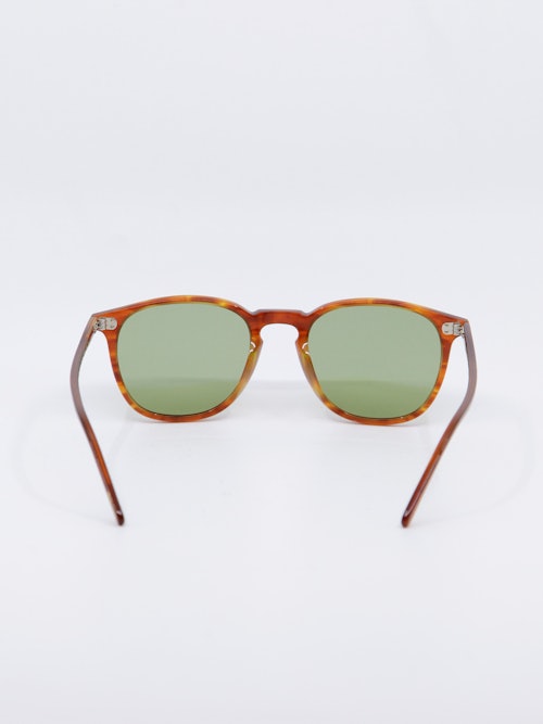 Solbrille i lysebrun karamellfarget ramme og lysgrønne glass, bakfra