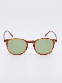 Solbrille i lysebrun karamellfarget ramme og lysgrønne glass, bilde foran