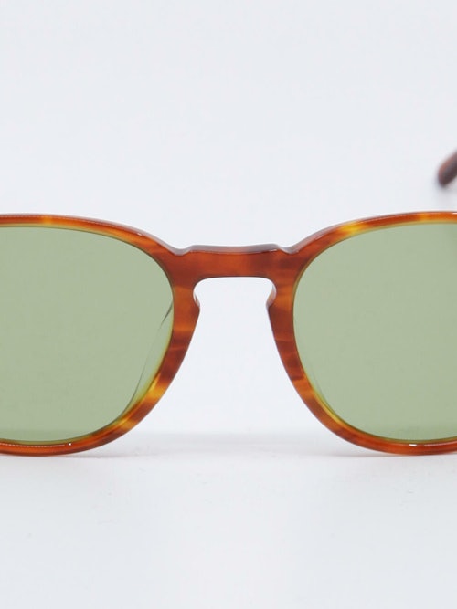 Solbrille i lysebrun karamellfarget ramme og lysgrønne glass, nærbilde