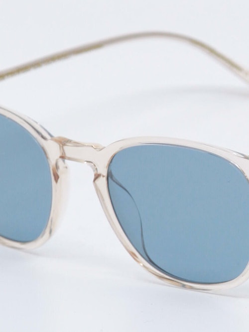 Solbrille med transparent ramme og blå glass, bilde nær