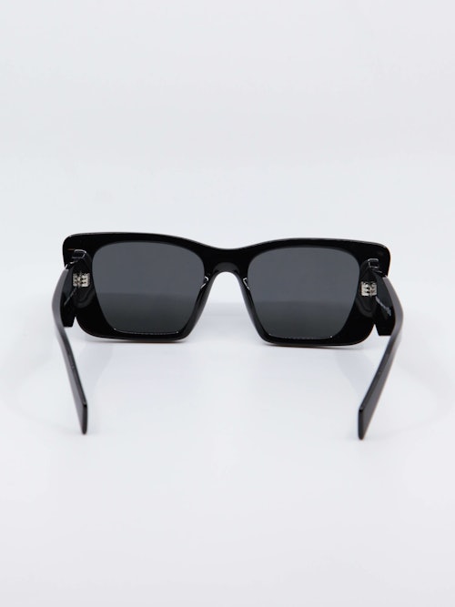 Sort solbrille i klassisk cateye form med grå glass, bilde bakfra