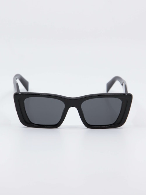 Sort solbrille i klassisk cateye form med grå glass, bilde forfra