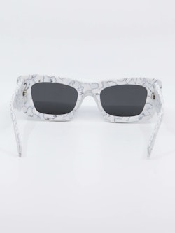 Hvit solbrille med marmordesign og svarte glass, bilde bakfra
