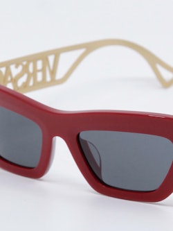 Rød solbrille med grå glass, nærbilde