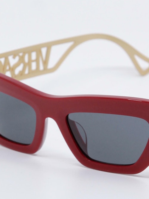 Rød solbrille med grå glass, nærbilde