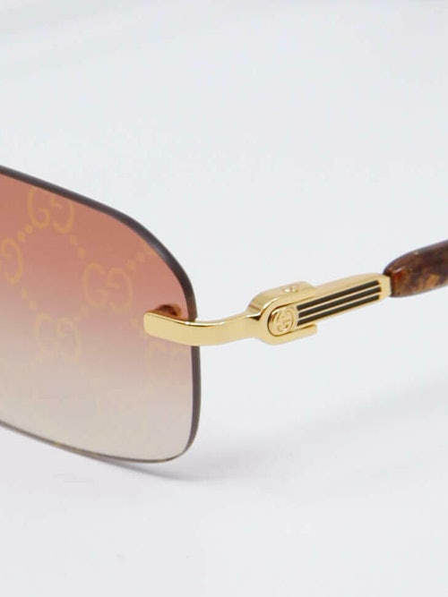Solbrille fra Gucci med gulldetaljer, og peach-farget glass, detaljbilde