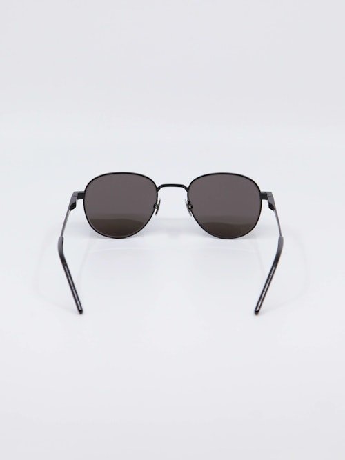 Svart solbrille fra Saint Laurent, runde glass og tynne brillestenger, bilde bakfra