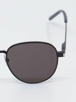Svart solbrille fra Saint Laurent, runde glass og tynne brillestenger, bilde forfra, nærbilde